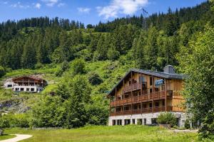 a house on the side of a hill with trees at Hotel Tetras Lodge in Tignes