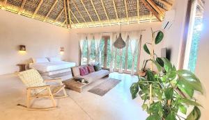 a bedroom with a bed and a couch and a plant at YAM HOTEL in Mazunte
