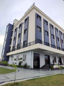 a large white building with a balcony at Status Club in Hardoī