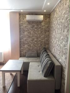 a living room with a couch and a stone wall at Apartment-Lawina in Sumy