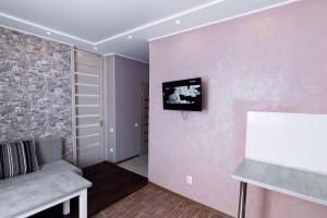 a living room with a couch and a tv on a wall at Apartment-Lawina in Sumy