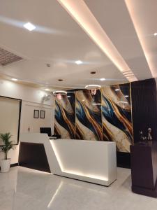 a lobby with a large painting on the wall at Status Club in Hardoī