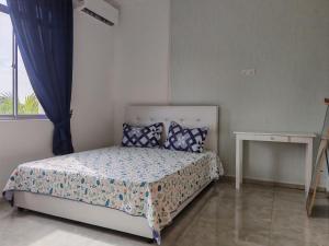 a bedroom with a bed and a window at Tetiba Suite in Muar
