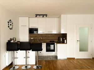 a kitchen with white cabinets and black appliances at Apartman Sučić in Livno