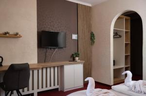 a room with a desk and a chair and a tv at Hotel Amadeus in Budapest