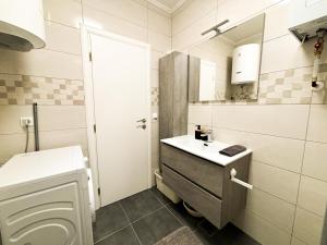 a white bathroom with a sink and a toilet at Apartman Sučić in Livno +6 photos