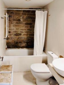 a bathroom with a white toilet and a bath tub at Equisoain Ala Sur in Monreal