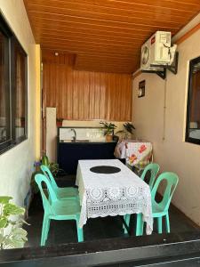 eine Terrasse mit Tisch, Stühlen und einem Waschbecken in der Unterkunft Lucy's Tiny Homes in Puerto Princesa