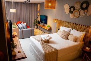 a bedroom with a bed and a living room at Studio River 101 in Pôrto de Pedras