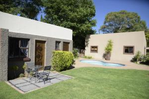 a house with a table and chairs in the yard at Easy Inn Guesthouse in Welkom