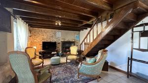 a living room with chairs and a staircase at Le gîte de nathye in Saint-Junien