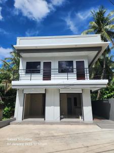 a white house with a balcony on top of it at Daniel's Comfort Studio in Hipusñgo