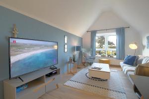 a living room with a large flat screen tv at Sie4-11 in Dorum-Neufeld