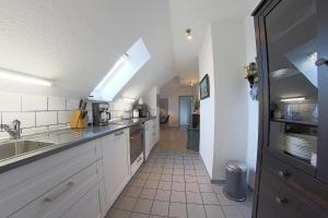 a large kitchen with white cabinets and a sink at Sie4-11 in Dorum-Neufeld