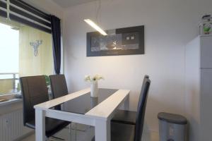 a white dining room table with a vase of flowers on it at Apartment 256 in Hohegeiß