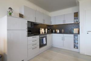 a white kitchen with white cabinets and appliances at Apartment 256 in Hohegeiß