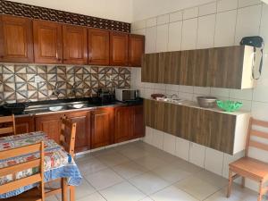 a kitchen with wooden cabinets and a table and a table and chairs at Casa em Praia Formosa in Cabedelo