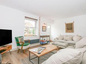 a living room with a couch and a tv at Joy's Cottage in King's Lynn