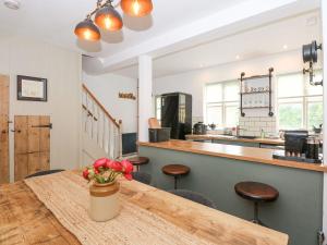 a kitchen with a wooden table with a vase of flowers at Joy's Cottage in King's Lynn