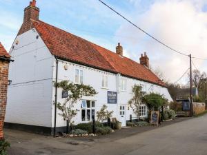 a white building with a red roof at Joy's Cottage in King's Lynn