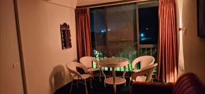 a room with a table and chairs and a window at Soni & Avi View Apartment in Igatpuri