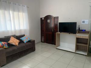 a living room with a couch and a flat screen tv at Casa em Praia Formosa in Cabedelo