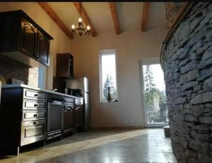 a kitchen with a stone wall and a counter top at Casa Picătura de Rouă in Beliş