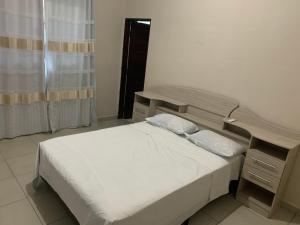 a small bedroom with a bed and a window at Casa em Praia Formosa in Cabedelo +36 photos