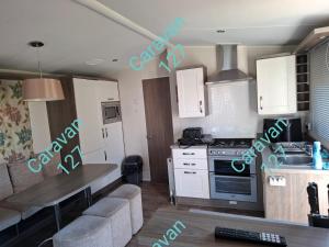 a kitchen with a table and a stove top oven at Caravan 127 in Barmouth