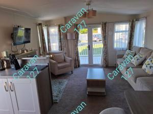 a living room with a couch and a table at Caravan 127 in Barmouth
