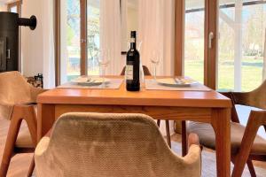 a wooden table with a bottle of wine and two glasses at Lokoschen in Lübbenau