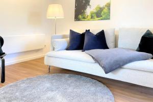 a living room with a white couch with blue pillows at Lokoschen in Lübbenau +27 photos