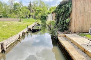 a small boat in a canal next to a building at Admiral in Lübbenau