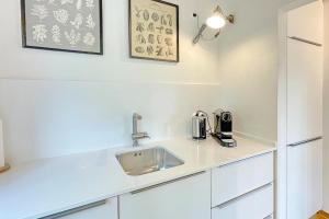 a kitchen with white cabinets and a sink at Admiral in Lübbenau
