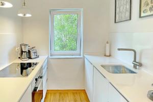 a white kitchen with a sink and a window at Admiral in Lübbenau +9 photos