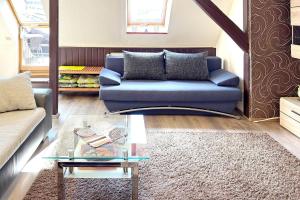 a living room with a blue couch and a glass table at An der Postmeilensäule in Lübbenau