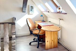an office in the attic with a desk and a chair at An der Postmeilensäule in Lübbenau