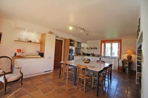 a kitchen with a table and chairs in a room at Domaine de gensignac in Séreilhac