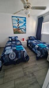 a bedroom with two beds and a lighthouse picture at Corona Del Mar 23 in Uvongo Beach +13 photos