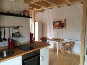 una cocina con fregadero y una mesa con un coche en la pared en Ferienwohnungen im Schwedenstil, en Papenburg