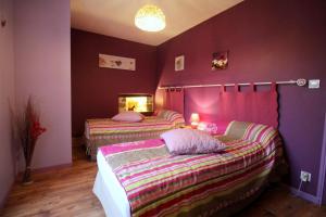 two beds in a room with purple walls at Mazette in Videix