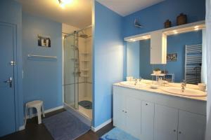 a blue bathroom with two sinks and a shower at Mazette in Videix +18 photos