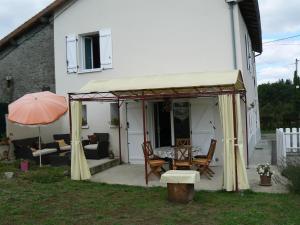a patio with a table and an umbrella at Mazette in Videix