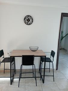 a dining room table with chairs and a clock on the wall at Apartment Akanthous in Kallithea Halkidikis