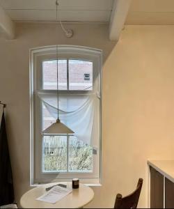 a window in a room with a table and a lamp at Maison 1882 in Hauwert +8 photos