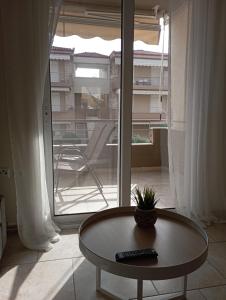 a coffee table in front of a large window at Apartment Akanthous in Kallithea Halkidikis