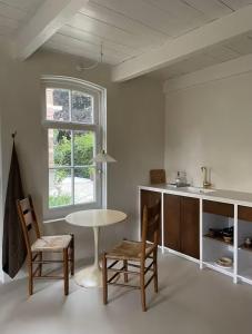 a kitchen with a table and chairs and a window at Maison 1882 in Hauwert