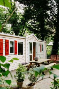 a white cabin with red doors and a picnic table at The Red Shutter Cottage in Hattemerbroek