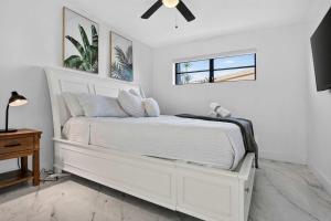 a white bed in a white bedroom with a ceiling fan at Hollywood Heated Pool Mini Golf Unique VR Room in Hollywood +54 photos