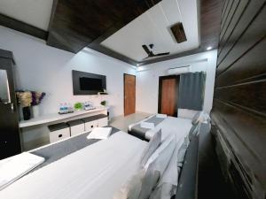 a hotel room with two beds and a tv at Evesta Micasa in Haridwār